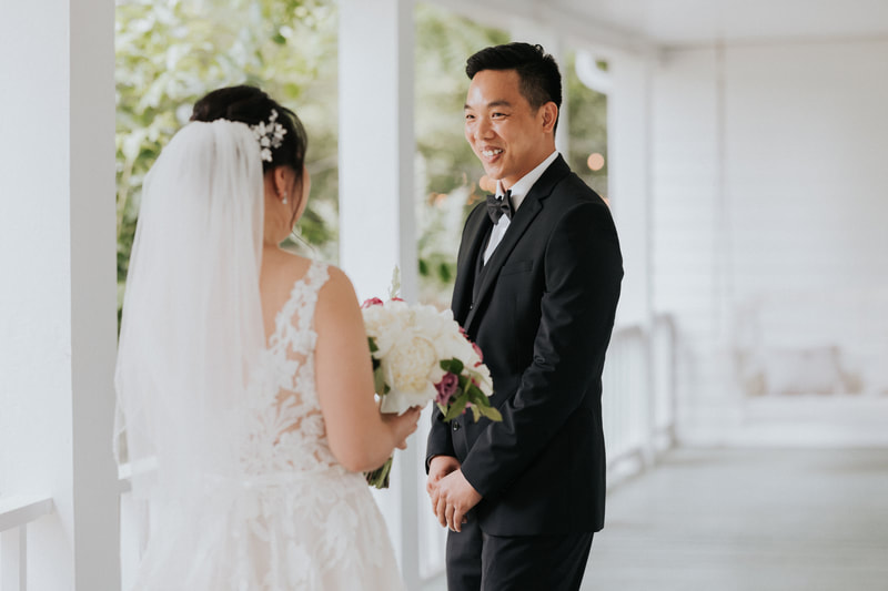bride and groom's first look on farmhouse porch