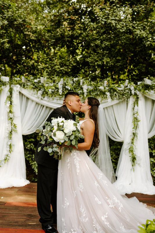 groom kissing bride at altar with theatre curtains