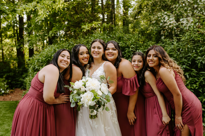 bridesmaids in mauve dresses posing with bride