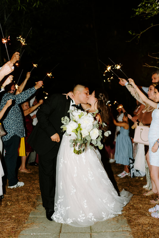 groom dips bride for kiss during sparkler exit