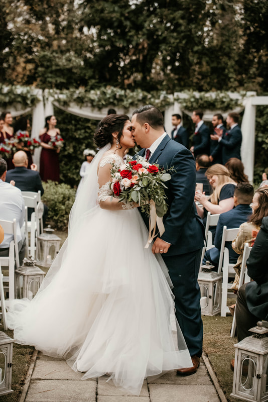 latino newlyweds kissing down aisle after ceremony