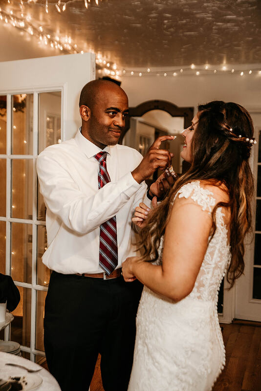 groom putting icing on brides nose during cake cutting