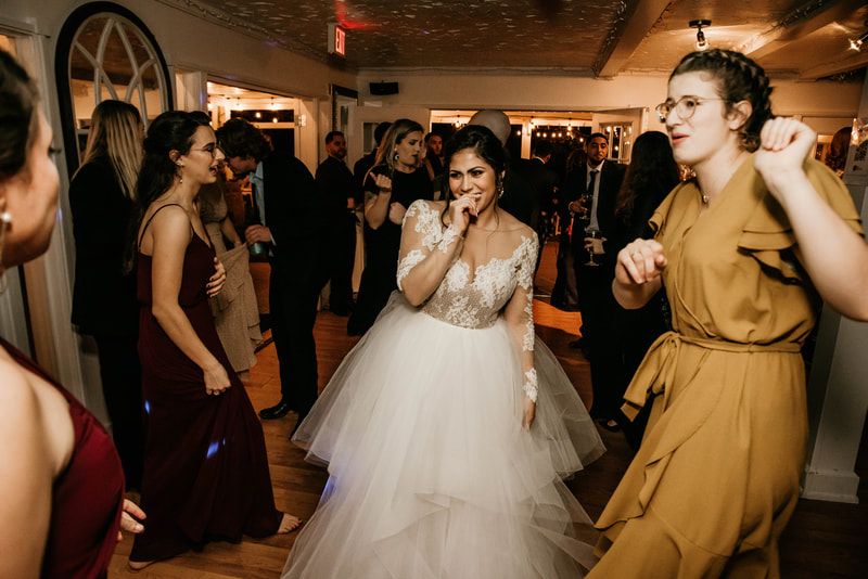 bride dancing with friends on carriage house dance floor
