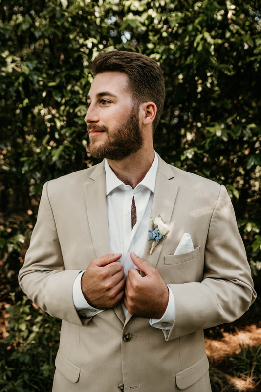 groom in tan suit with dusty blue details