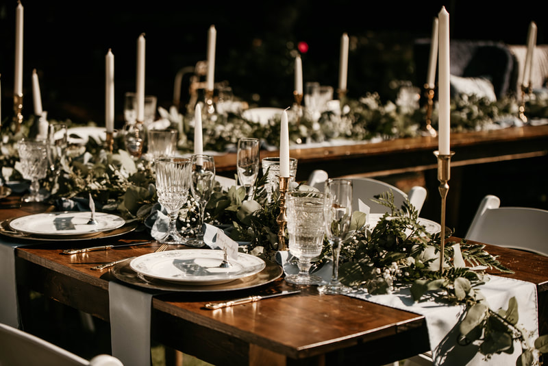 wooden wedding party table with greenery and candles