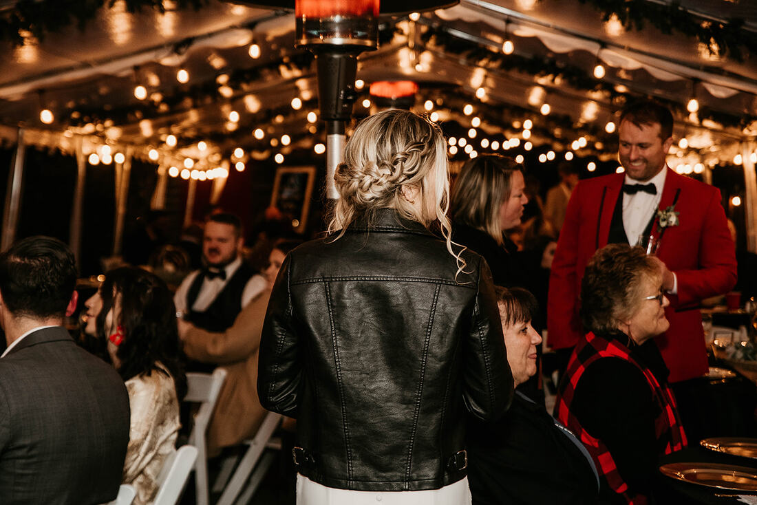bride in leather jacket at tented reception