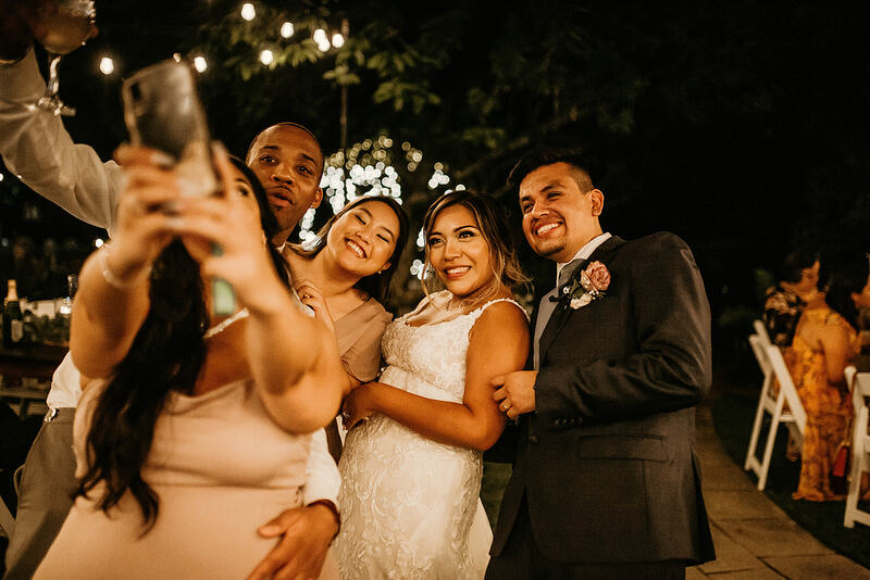 wedding guests taking selfie with newlyweds