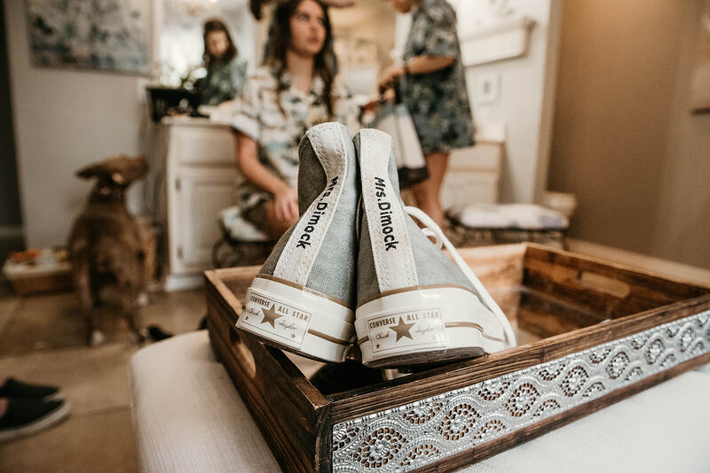 bride's converse with new last name sitting in bridal suite