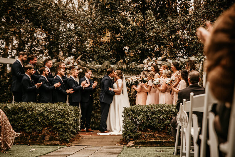 bride and groom kissing at garden ceremony