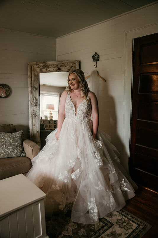 bride in ballroom dress posing in neutral farmhouse room