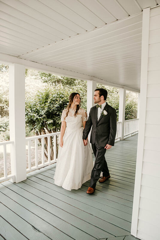 bride and groom walking on farmhouse front porch
