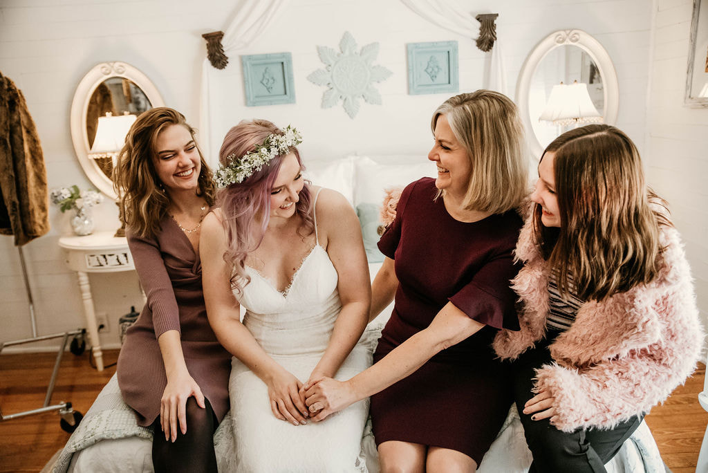 bride with sisters and mom in Four Oaks Manor's bridal bedroom