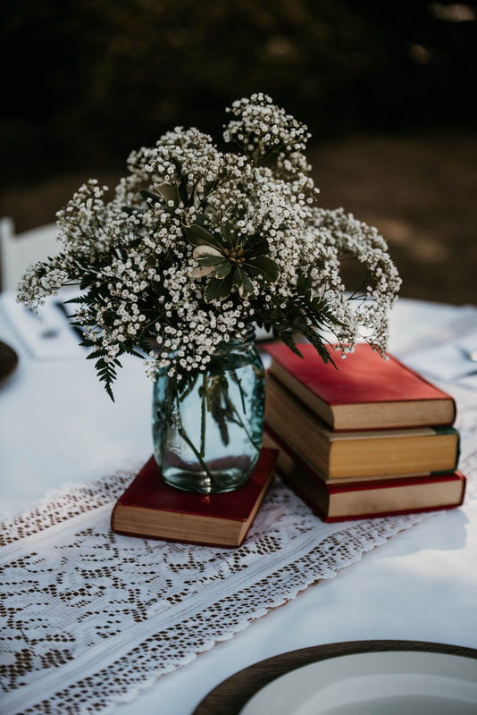 vase with white flowers on vintage book for centerpiece