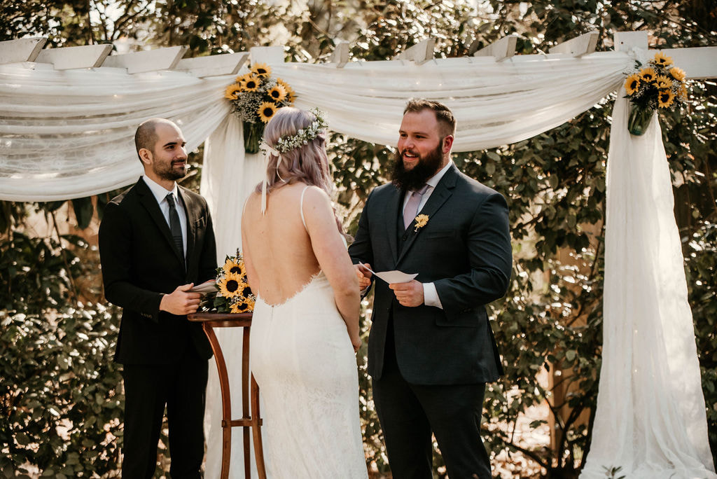 groom saying custom vows during outdoor spring wedding