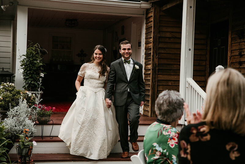 bride and groom walking down porch steps into reception