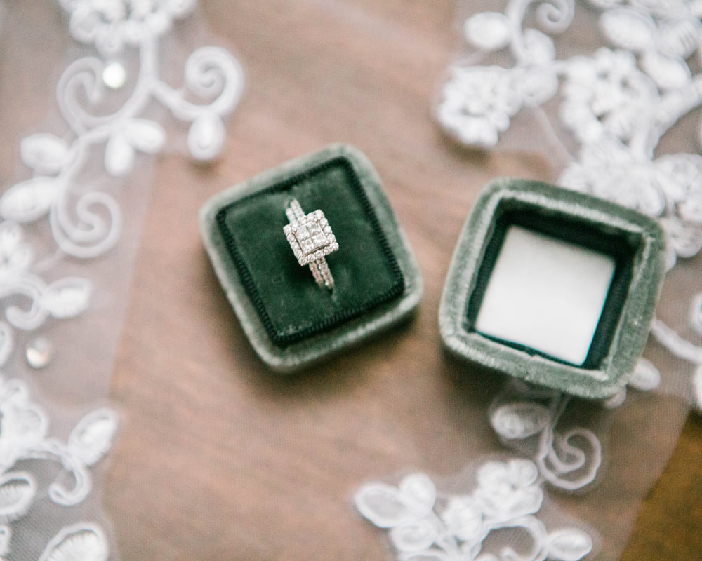 Princess shaped diamond engagement ring in velvet box.