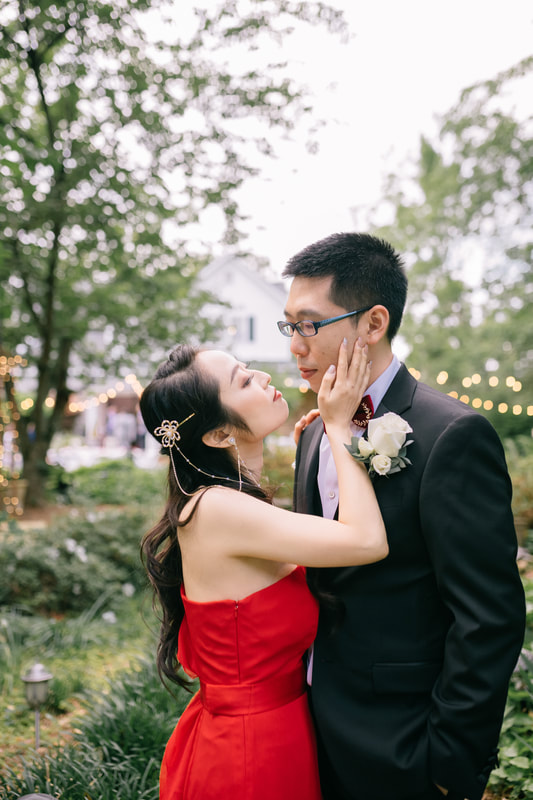 chinese bride in red dress posing with groom in gardens