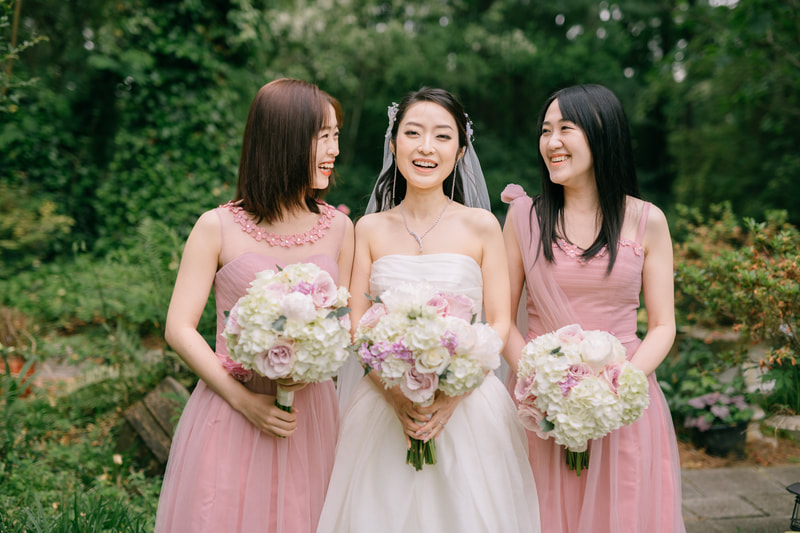 bride laughing with bridesmaids in garden