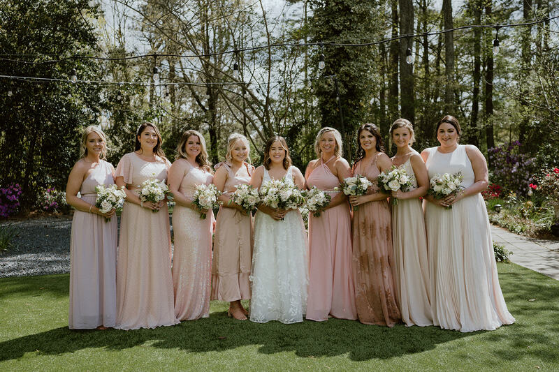 spring bridal party in mismatched blush dresses at garden venue
