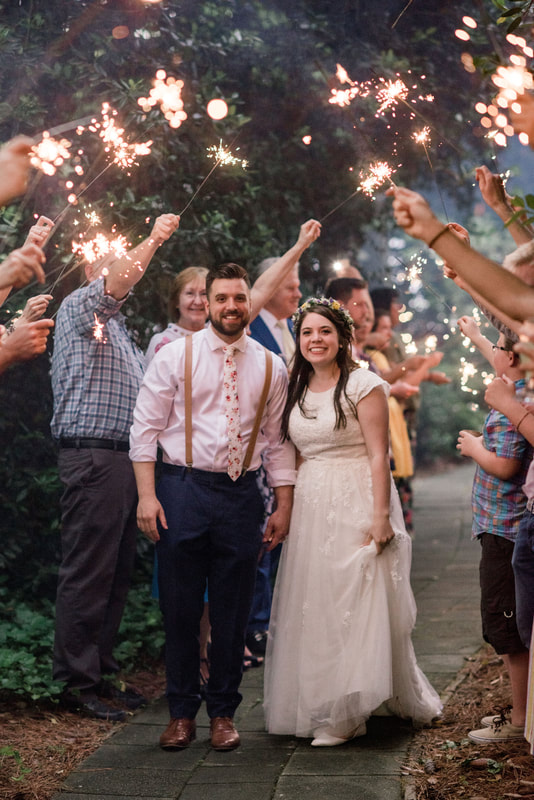 newlyweds smile during sparkler grand exit